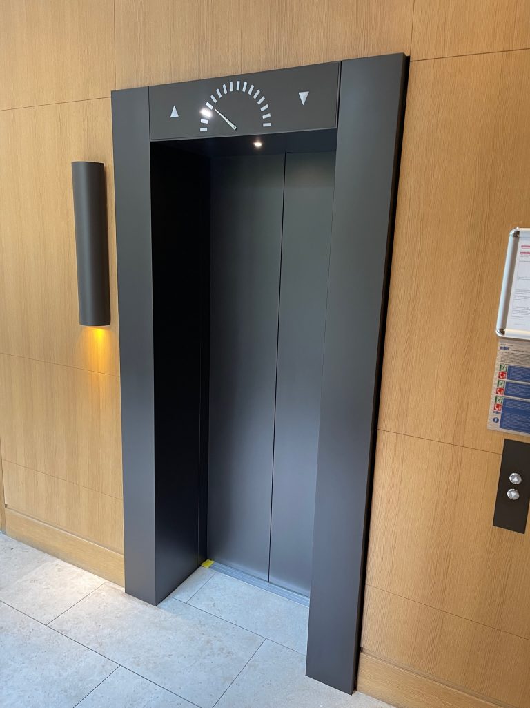 a brand new lift entrance following spray painting and panel repairs