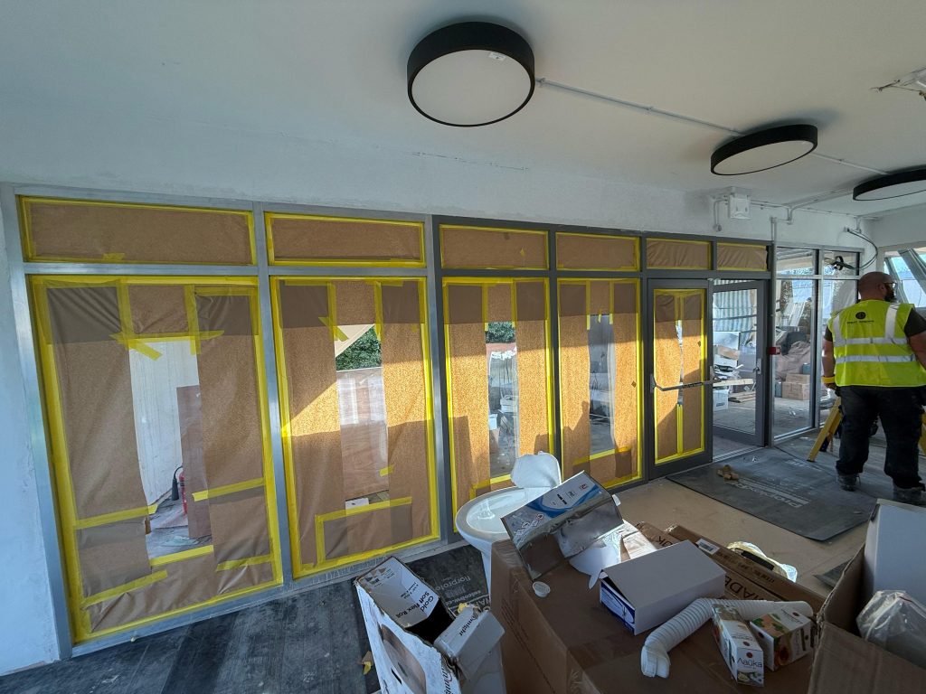Curtain wall frames masked for spraying with an operative at work in Chelmsford