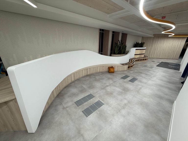 Curved white reception desk after on-site paint spraying in Marylebone